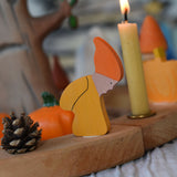 A close up of a Grimm's Autumn dwarf decorative figure placed on a natural celebration ring. 