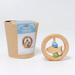 The Grimm's baby Grasping Toy Little Fish With Wooden Discs pictured next to it's plastic free cardboard packaging box.