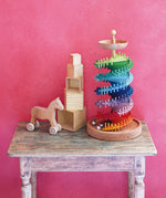 Grimms handcrafted wooden ball run assembly set displayed with natural stacking cubes and push along horse