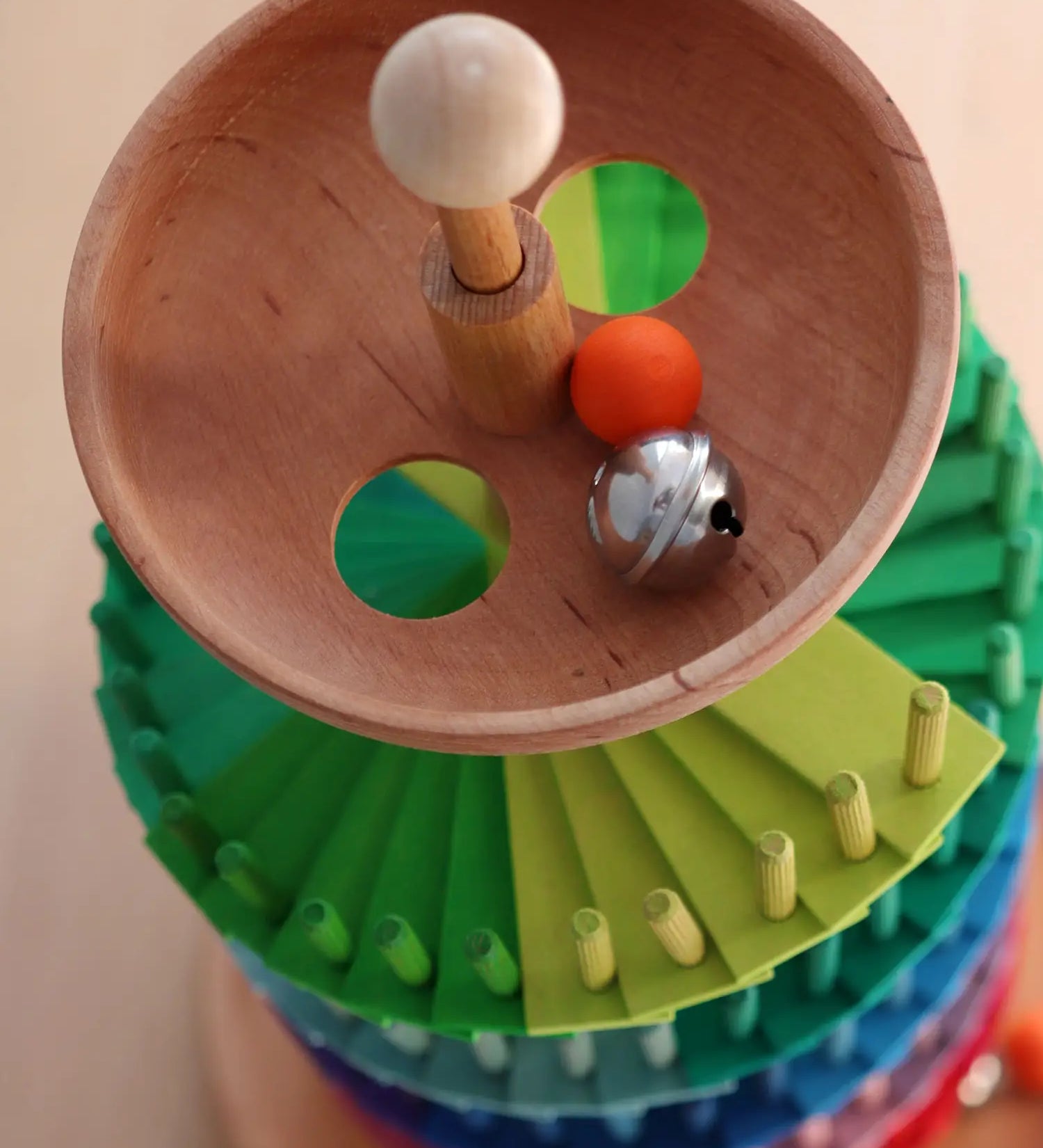 Grimms handcrafted wooden ball run assembly set showing a close up of the start bowl with a wooden marble and bell inside