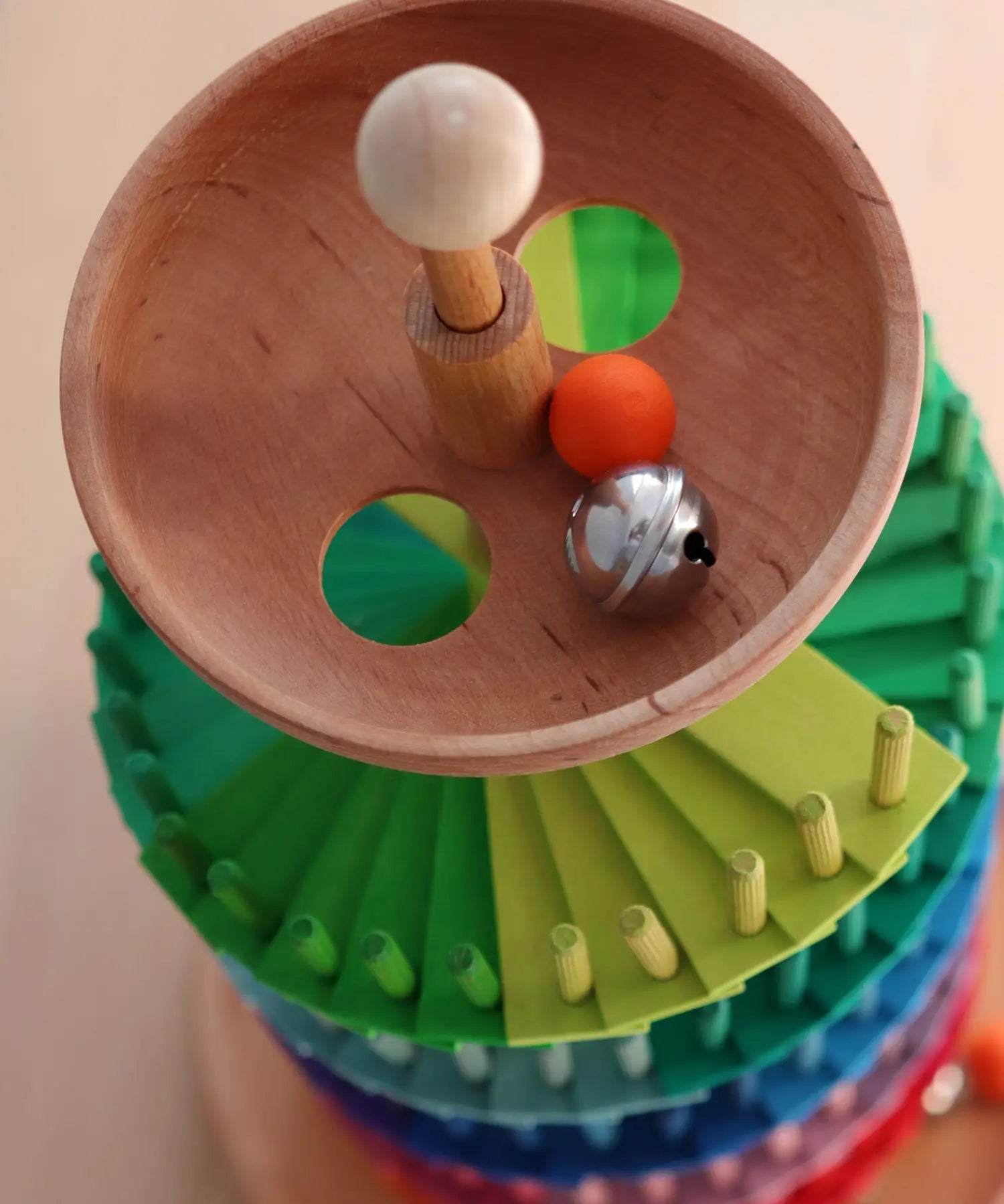 Grimms handcrafted wooden ball run assembly set showing a close up of the start bowl with a wooden marble and bell inside