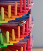 Grimms handcrafted wooden ball run assembly set showing a close up of a marble running down the colourful slats
