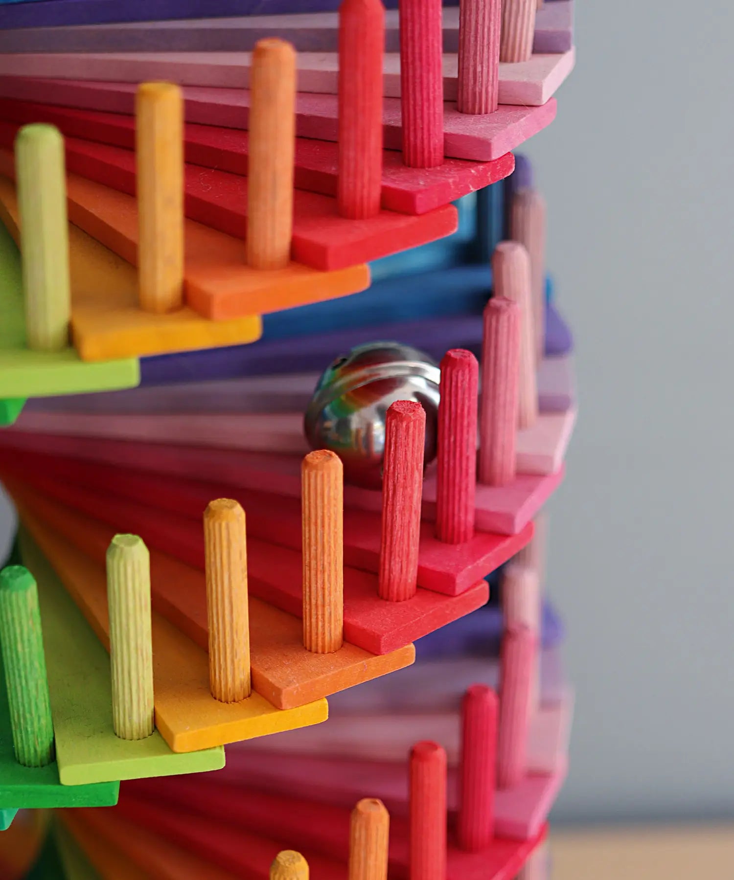 Grimms handcrafted wooden ball run assembly set showing a close up of a marble running down the colourful slats