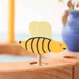 A Grimm's bee decorative figure placed on a natural Grimm's celebration ring. The bee is part of a wide range of Waldorf inspired decorative figures available here at Babipur. 