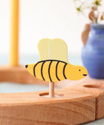 A Grimm's bee decorative figure placed on a natural Grimm's celebration ring. The bee is part of a wide range of Waldorf inspired decorative figures available here at Babipur. 
