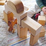 Child playing with the Grimm's giant natural wooden building blocks set.
