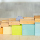 A coin down a wooden rail on top of the Grimms large pastel building boxes