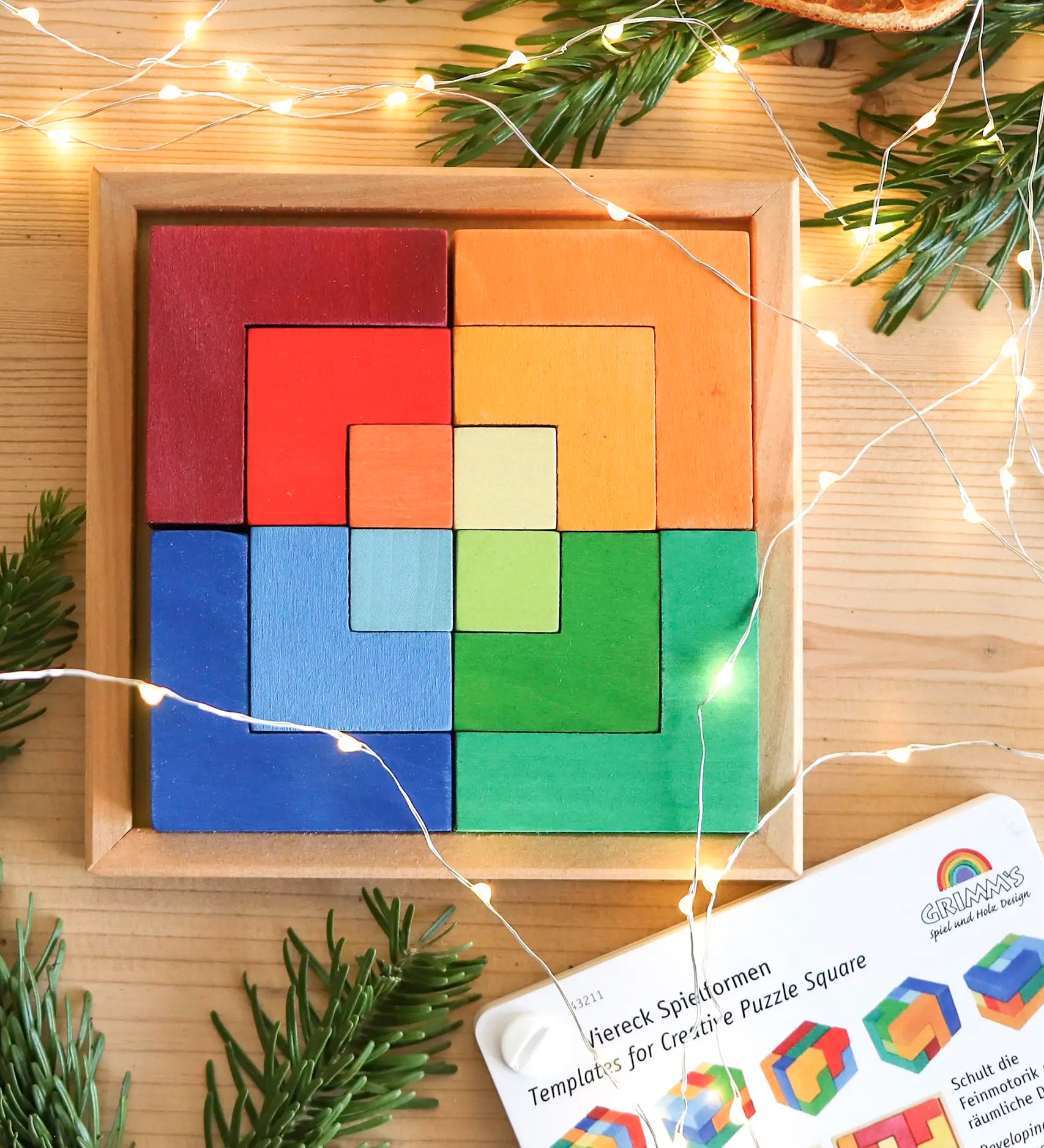 Grimm's puzzle square booklet displayed next to a compatible wooden square creative set 