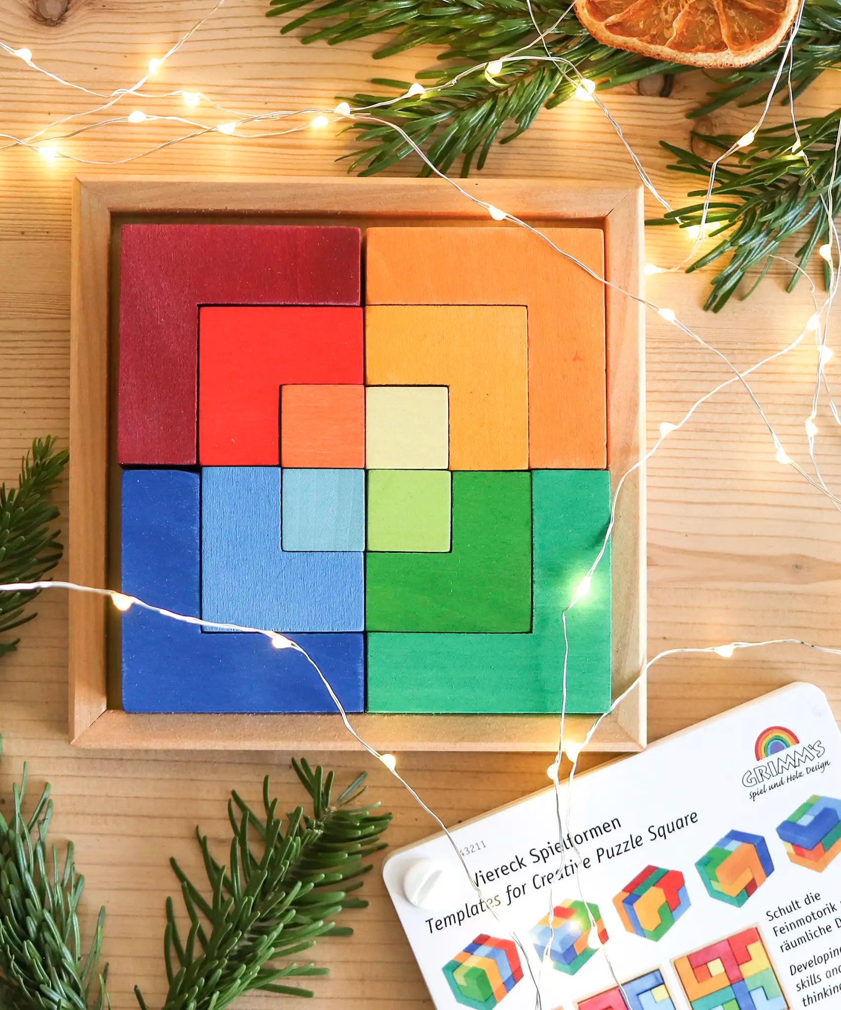 Grimm's puzzle square booklet displayed next to a compatible wooden square creative set 
