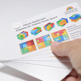 Adult hand holding the Grimm's puzzle square booklet showing scale