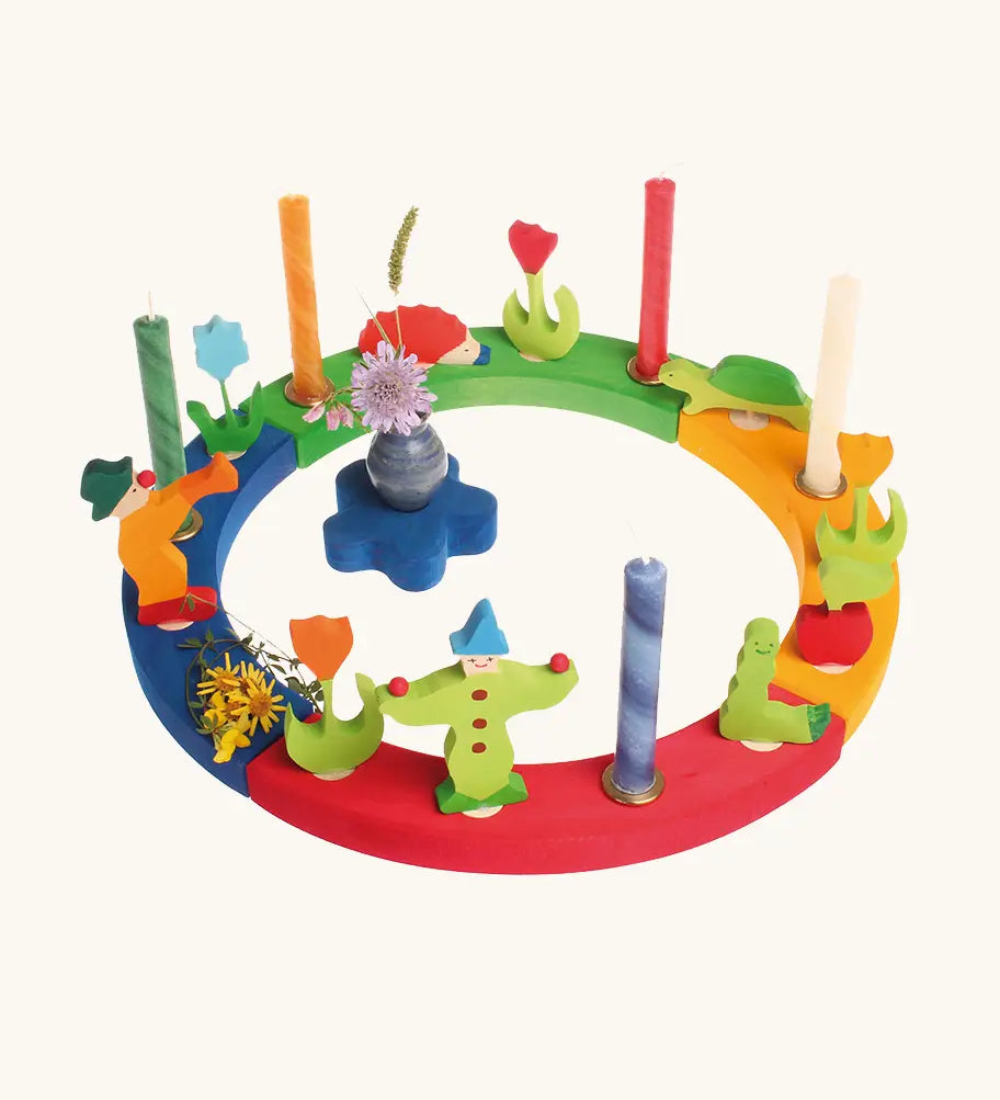Grimm's wooden celebration ring displaying various decorative figures including clowns worm, hedgehog and tulips