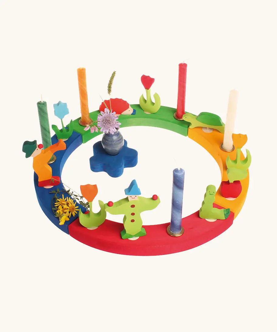 Grimm's wooden celebration ring displaying various decorative figures including clowns worm, hedgehog and tulips