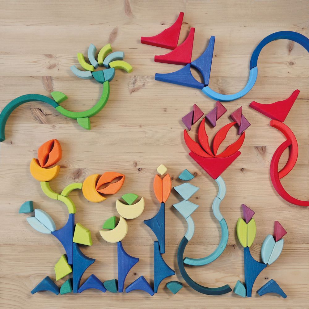 Grimm's Arcs in Squares Wooden Building Set blocks used to create a floral flatlay.