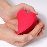 A close up of the red coloured heart in a person's hands.