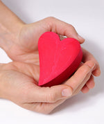 A close up of the red coloured heart in a person's hands.
