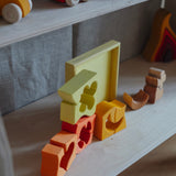 The yellow an natural wooden blocks from the Grimm's yellow building set stacked up on top of each other. These Grimm's toys are part of a wide range of wooden toys available here at Babipur. 