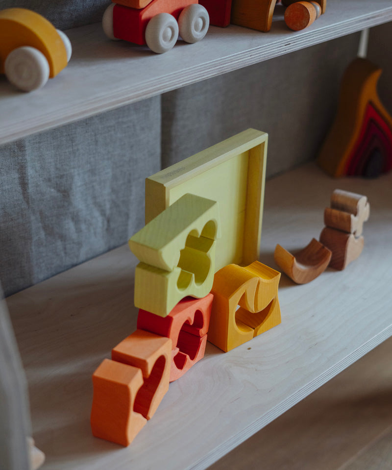The yellow an natural wooden blocks from the Grimm's yellow building set stacked up on top of each other. These Grimm's toys are part of a wide range of wooden toys available here at Babipur. 