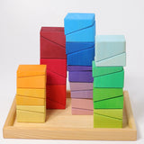 Grimm's sloping blocks building set blocks shown stacked up on the wooden storage display tray.