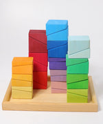 Grimm's sloping blocks building set blocks shown stacked up on the wooden storage display tray.