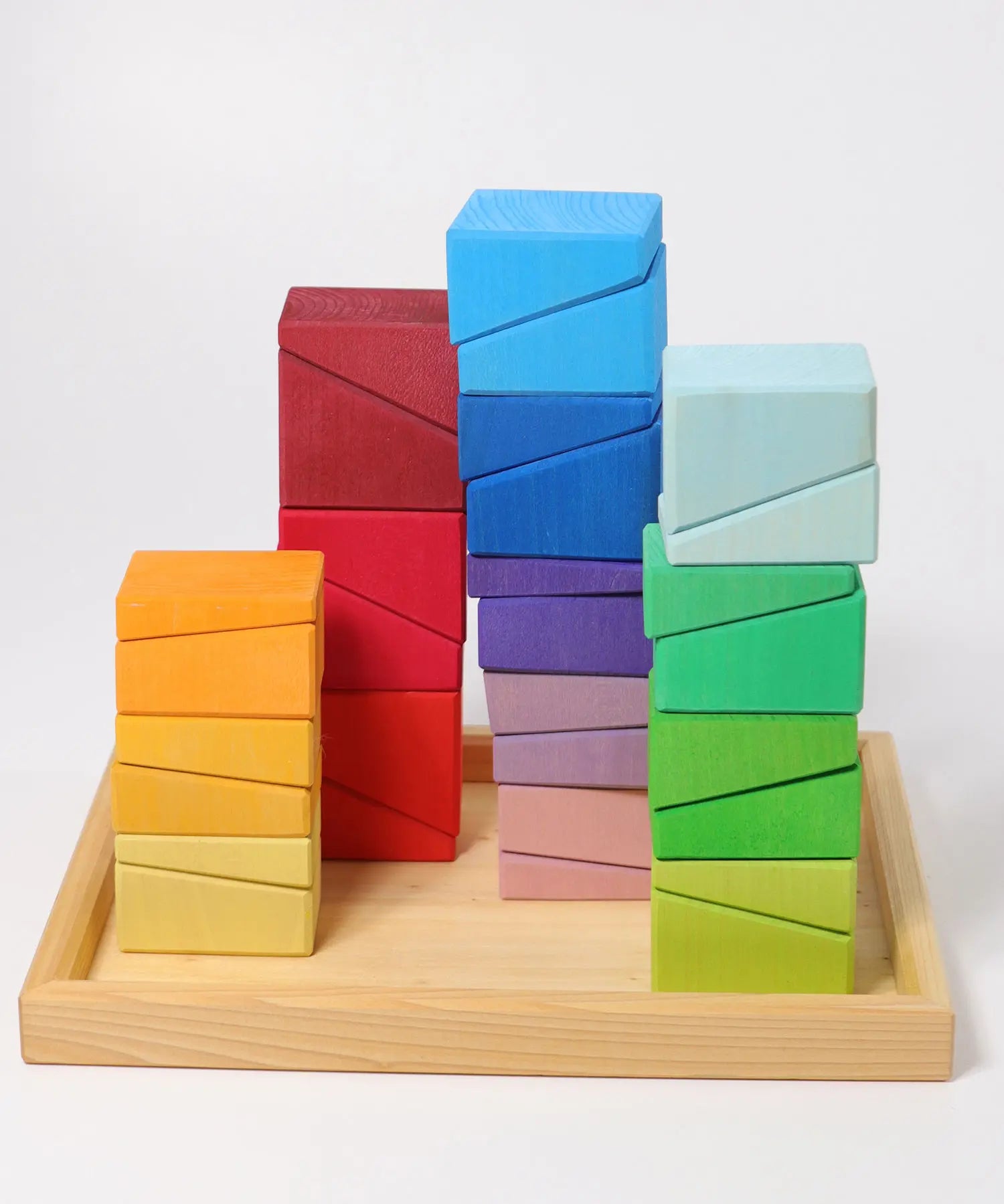 Grimm's sloping blocks building set blocks shown stacked up on the wooden storage display tray.