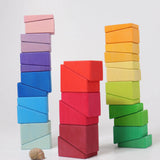 Blocks from the Grimm's sloping blocks building set stacked up in three stacks.