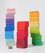 Blocks from the Grimm's sloping blocks building set stacked up in three stacks.