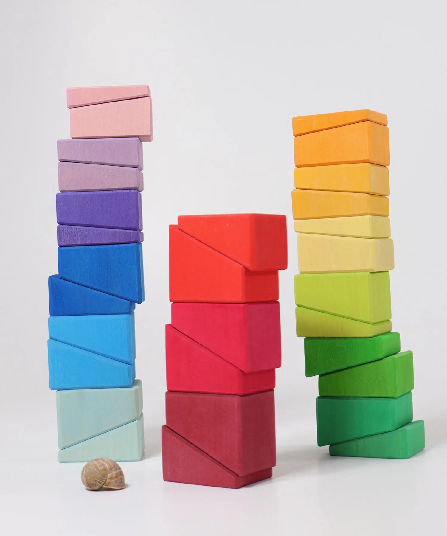Blocks from the Grimm's sloping blocks building set stacked up in three stacks.