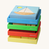 Four Grimm's building sets stacked up. The blue sailing boat design set is on the top.Four different sets each containing a set of shaped blocks that sit in a coloured wooden storage tray. These Grimm's toys are part of a wide range of wooden toys available here at Babipur. 