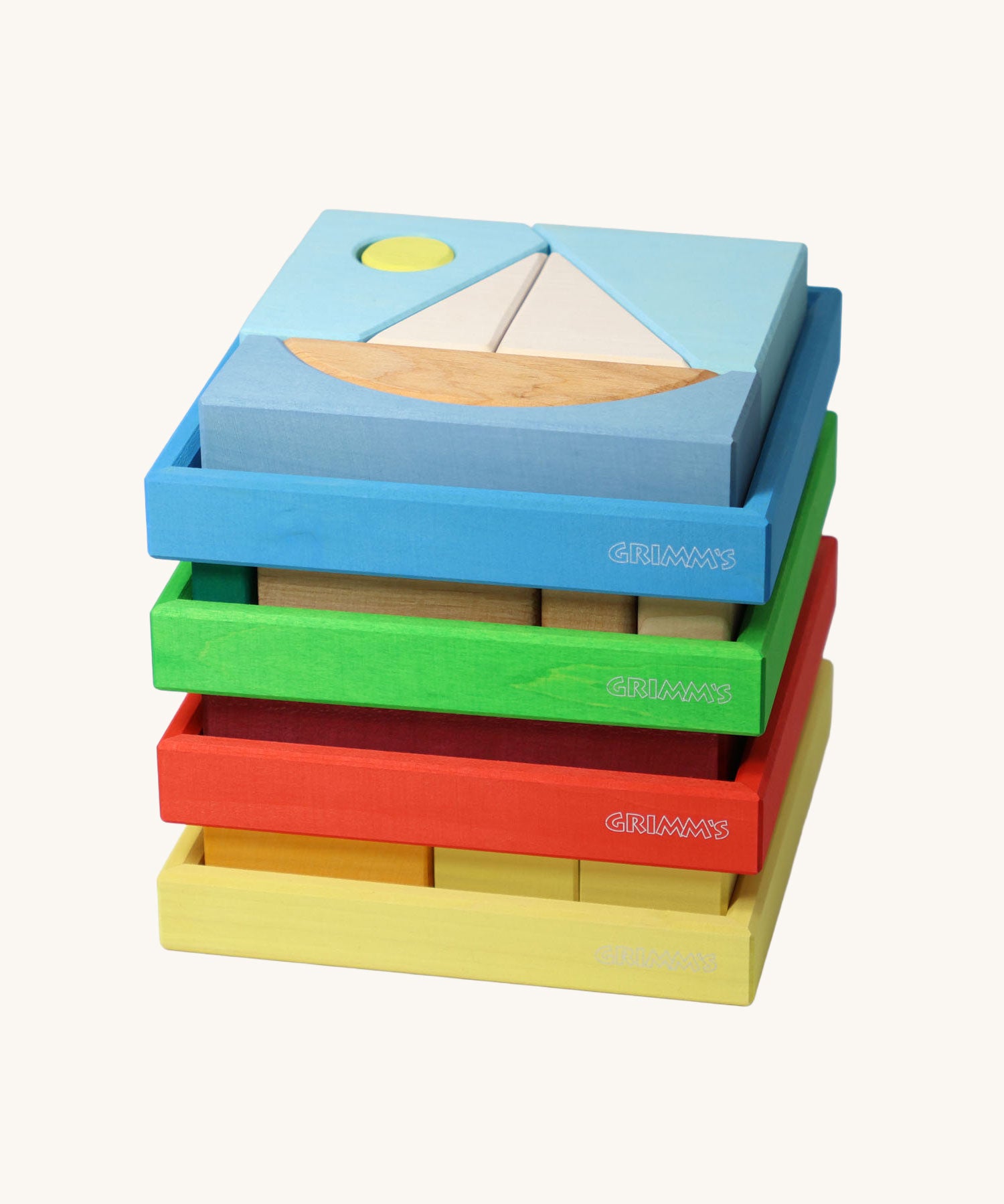 Four Grimm's building sets stacked up. The blue sailing boat design set is on the top.Four different sets each containing a set of shaped blocks that sit in a coloured wooden storage tray. These Grimm's toys are part of a wide range of wooden toys available here at Babipur. 