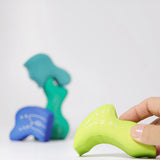 Adult holding a piece from the Grimm's casa aqua wooden toy stacking puzzle. Four piece simple wooden block puzzle toy in a mix of blue and green colours. 