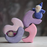 Grimm's handcrafted wooden casa coral blocks stacked with a small dwarf doll standing on top