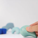 Adult's hand holding a piece from the Grimm's casa luna wooden stacking puzzle toy. Simple 4 piece blue blocks stacking toy. 