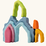 Grimm's cave arch stacker pastel wooden toy used in a stack.