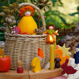 A cosy Autumn time display using a Grimm's Waldorf Celebration Ring, various Grimm's decorative figures and Grimm's Candles with a small basket in the middle holding various Ambrosius and Grimms figures available at Babipur.