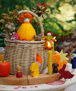 A cosy Autumn time display using a Grimm's Waldorf Celebration Ring, various Grimm's decorative figures and Grimm's Candles with a small basket in the middle holding various Ambrosius and Grimms figures available at Babipur.