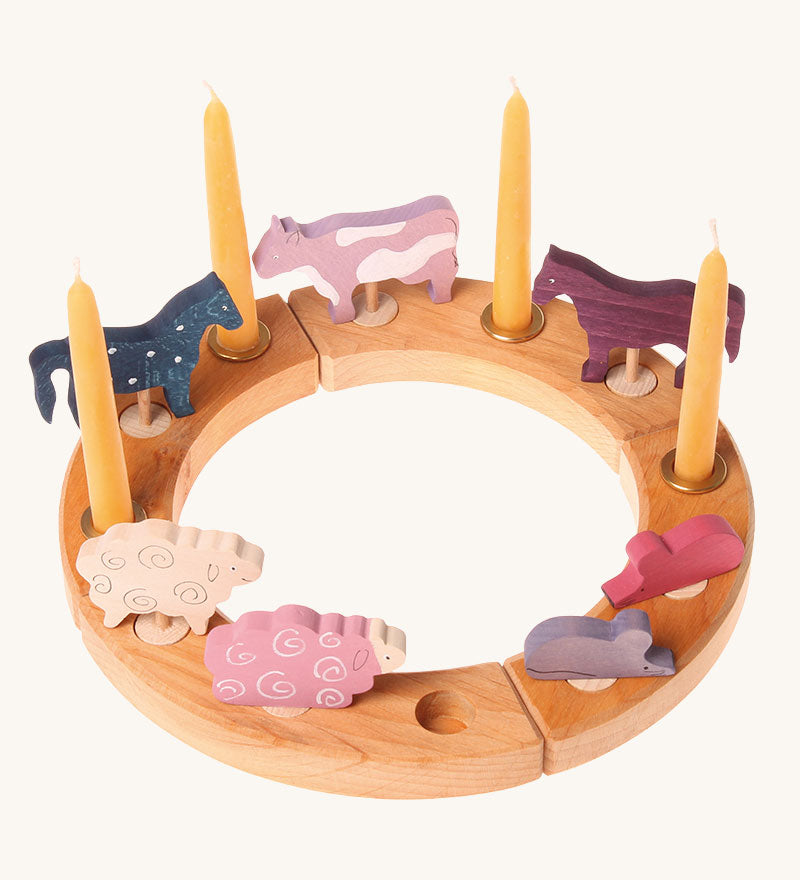 A natural Grimm's celebration figure decoreated with wooden figures and candles. These Waldorf inspired decorative figures are part of a wide range of wooden decorations for celebration rings available here at Babipur.