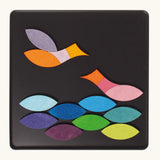A pair of birds in flight using the Grimm's bright wooden triangular magnetic pieces displayed in a tin 