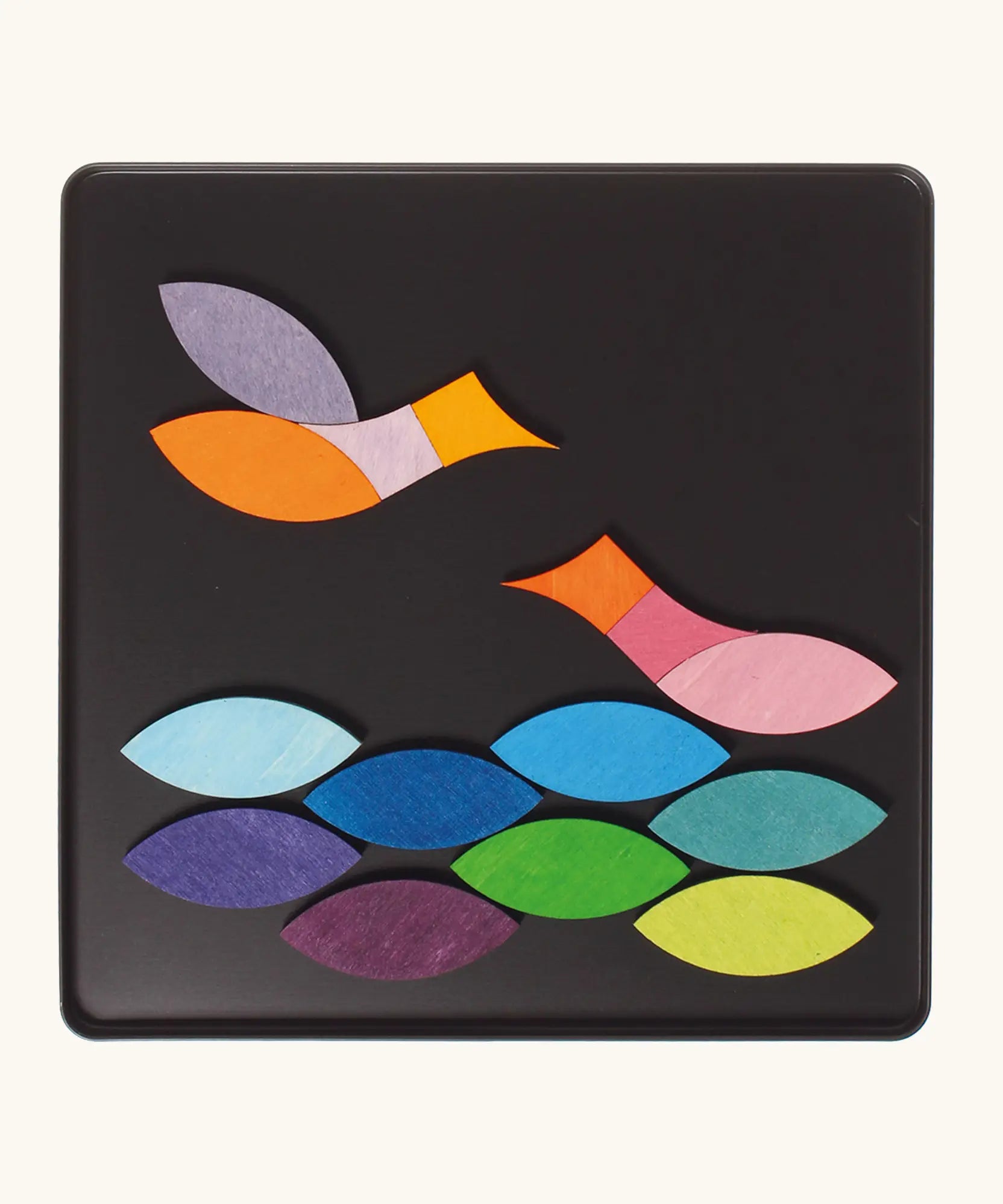 A pair of birds in flight using the Grimm's bright wooden triangular magnetic pieces displayed in a tin 