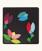 A flower and butterfly using the Grimm's bright wooden circular magnetic pieces displayed in a tin 