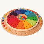 Grimm's Circular Disc & 35 Marbles with the Grimm's annual ring on a plain background. 
