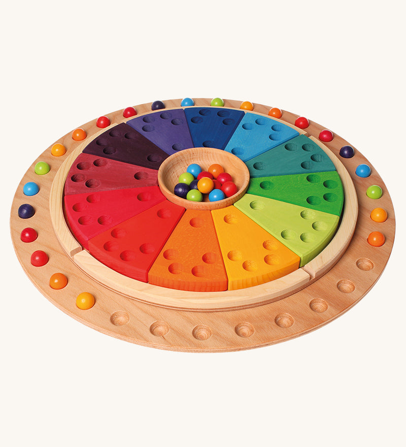 Grimm's Circular Disc & 35 Marbles with the Grimm's annual ring on a plain background. 
