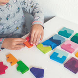 Grimm's concave finds convex wooden toy puzzle set played with by a child.
