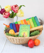 Grimms counting stack game displayed in a basket with a card game and flowers in the background