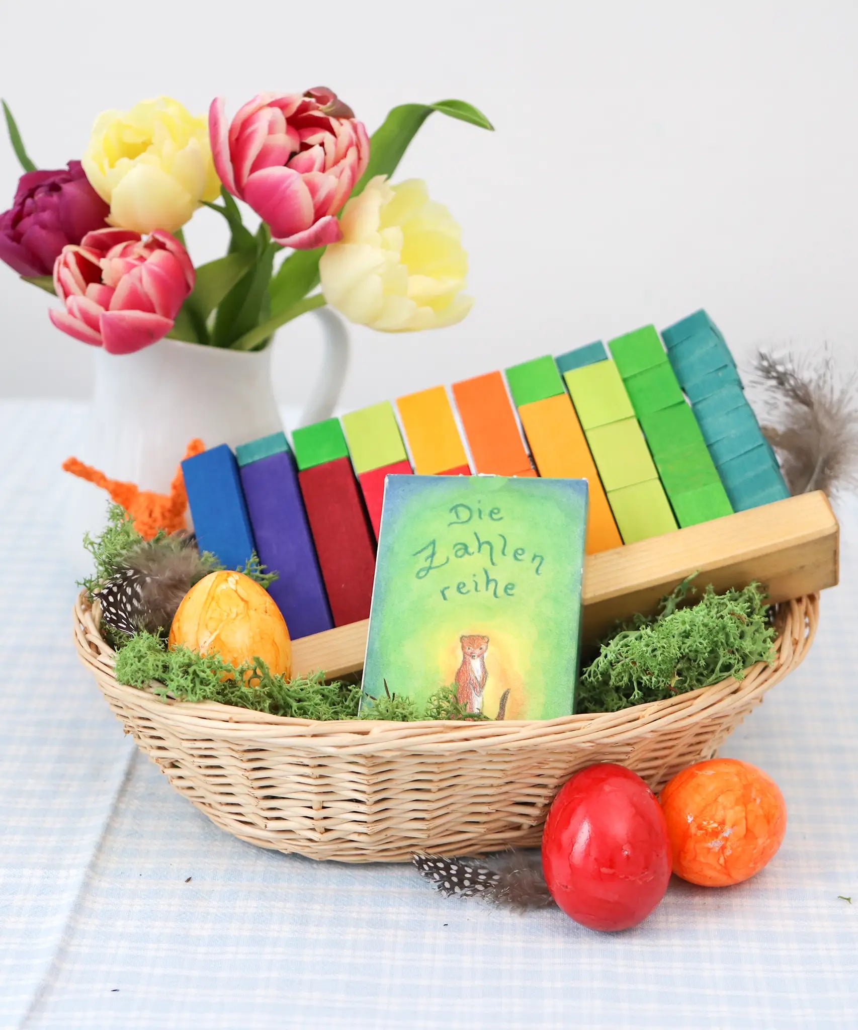 Grimms counting stack game displayed in a basket with a card game and flowers in the background