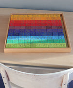 A Grimm's counting with colours educational set showing the blocks sitting in the wooden tray on a desk