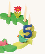 Grimm's Dark Green and Light Green Branches set up in a ring decorated with candles and decorative figures. 