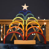 Grimm's Rainbow Stacking Tower stacked on the base in the shape of a tree with a wooden star placed on top.