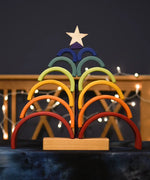 Grimm's Rainbow Stacking Tower stacked on the base in the shape of a tree with a wooden star placed on top.