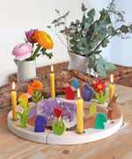 Grimm's celebration ring decoarted with dwarf and flowers decorative figures and candles.