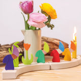 Grimm's seasonal dwarf decorative figures on a celebration ring along side tulip decorative figures and candles. 